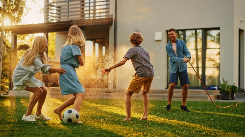 happy_family_of_four_playing_with_garden_water_shutterstock_6